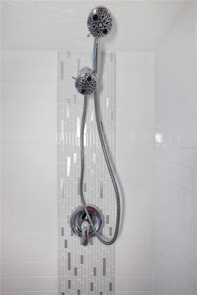 interior details featuring tiled shower