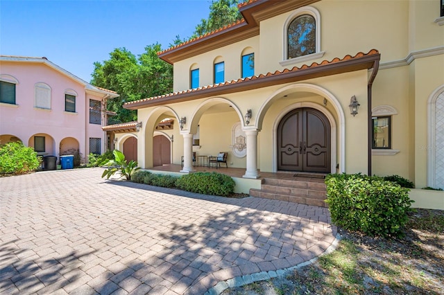 1966 Freedom Dr, Clearwater, FL 33755 - view of exterior entry featuring stucco siding, covered porch, and curved driveway