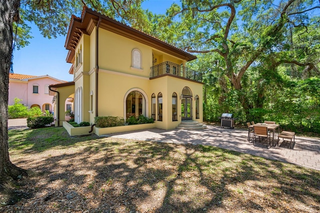 1966 Freedom Dr, Clearwater, FL 33755 - back of house featuring a balcony, french doors, stucco siding, and a patio area