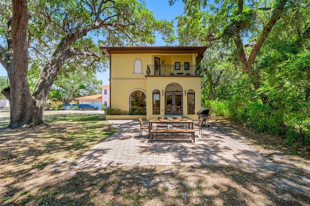 1966 Freedom Dr, Clearwater, FL 33755 - back of house with a balcony, french doors, stucco siding, and a patio