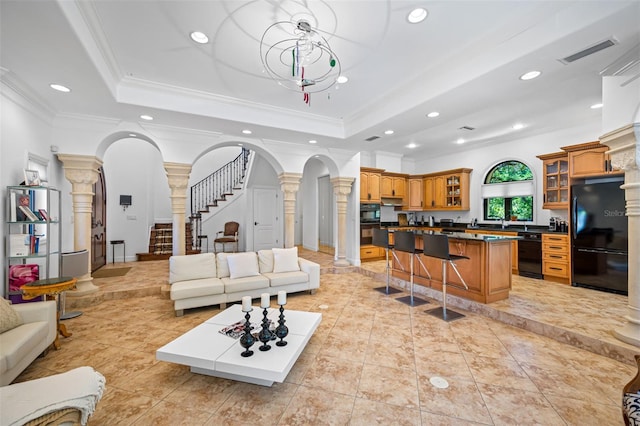 1966 Freedom Dr, Clearwater, FL 33755 - living room featuring decorative columns, a raised ceiling, arched walkways, recessed lighting, and crown molding
