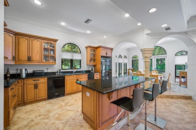 1966 Freedom Dr, Clearwater, FL 33755 - kitchen featuring black appliances, arched walkways, ornate columns, a breakfast bar area, and crown molding