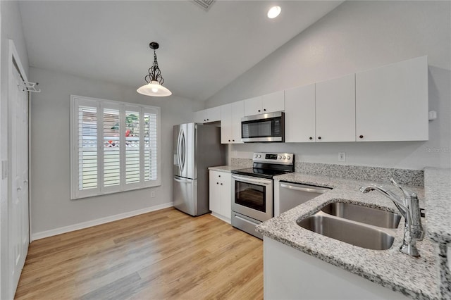 11932 Whisper Creek Dr, Riverview, FL 33569 - kitchen with stainless steel appliances, a sink, vaulted ceiling, decorative light fixtures, and white cabinetry