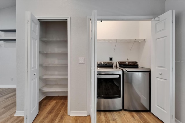 11932 Whisper Creek Dr, Riverview, FL 33569 - laundry room with washer and dryer, light wood-type flooring, and baseboards
