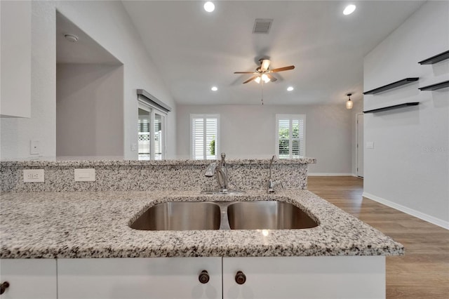 11932 Whisper Creek Dr, Riverview, FL 33569 - kitchen featuring a sink, a ceiling fan, light stone counters, light wood-type flooring, and recessed lighting