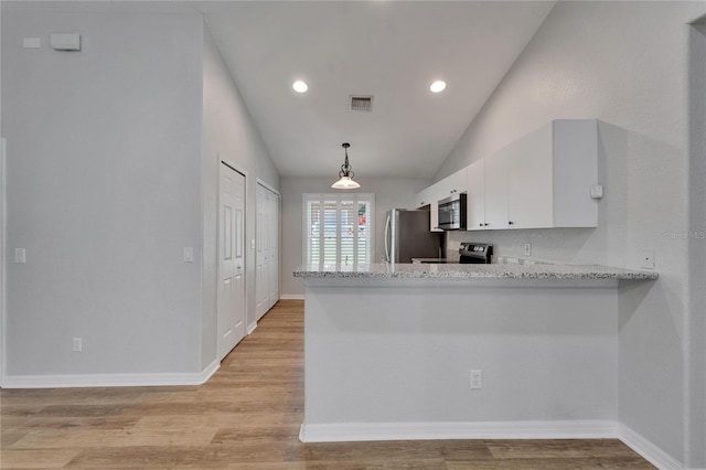 11932 Whisper Creek Dr, Riverview, FL 33569 - kitchen with appliances with stainless steel finishes, white cabinetry, a peninsula, lofted ceiling, and light wood-style flooring