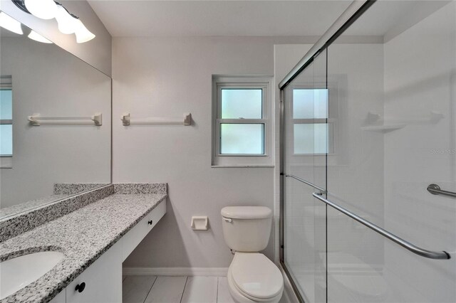 11932 Whisper Creek Dr, Riverview, FL 33569 - bathroom with baseboards, toilet, vanity, tile patterned flooring, and tiled shower
