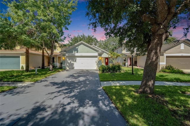 11932 Whisper Creek Dr, Riverview, FL 33569 - ranch-style home featuring stucco siding, a front lawn, a garage, and driveway