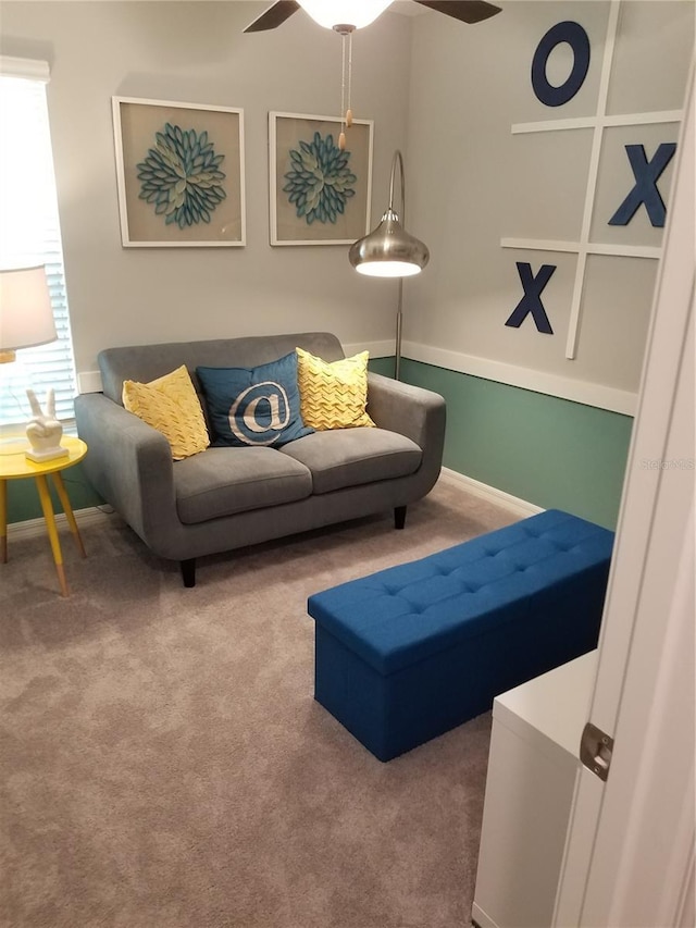 living room with a ceiling fan, carpet, and baseboards