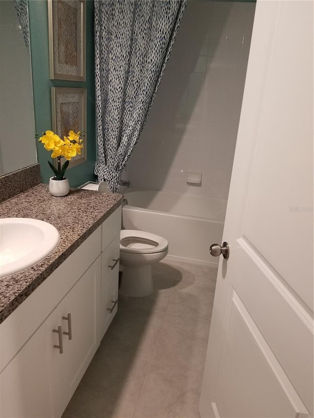 full bath featuring toilet, tile patterned flooring, washtub / shower combination, and vanity