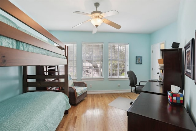 bedroom with baseboards, wood finished floors, and a ceiling fan