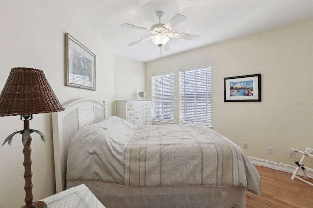 bedroom featuring a ceiling fan, wood finished floors, and baseboards