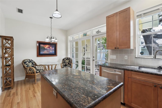 kitchen featuring decorative light fixtures, light wood-style floors, a kitchen island, dishwasher, and visible vents