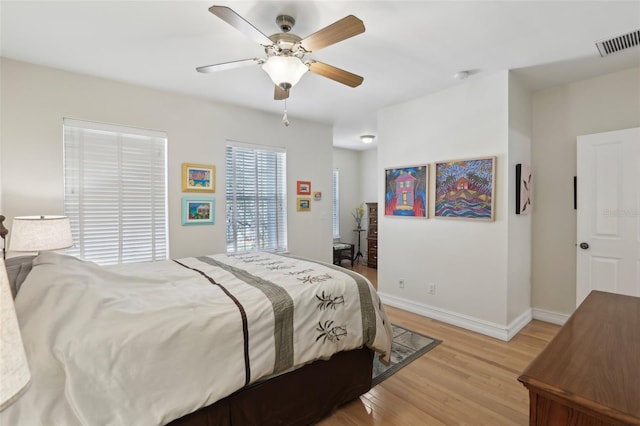 bedroom with a ceiling fan, visible vents, baseboards, and light wood-type flooring