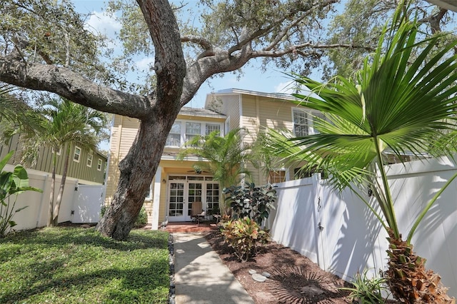 view of front facade featuring a gate, french doors, and a fenced backyard