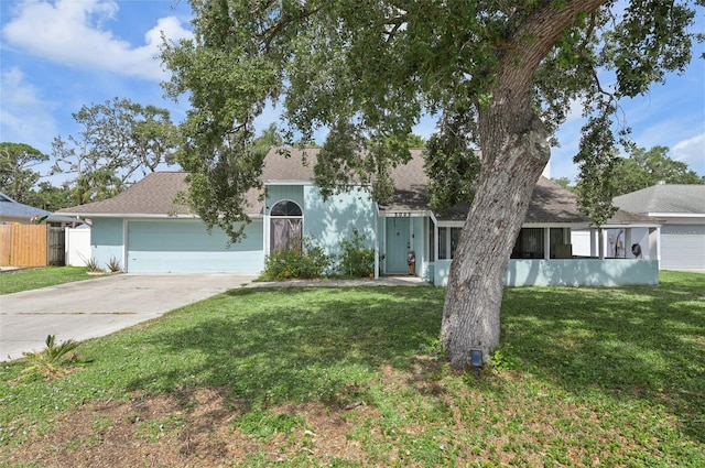 3093 Woodpine Cir, Sarasota, FL 34231 - view of front of house with fence, a shingled roof, a front lawn, a garage, and driveway