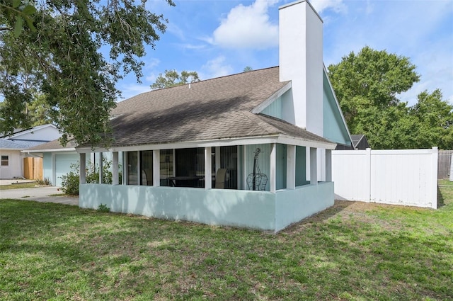 3093 Woodpine Cir, Sarasota, FL 34231 - rear view of house with fence, a shingled roof, a garage, a sunroom, and a yard