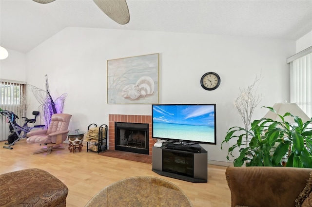 3093 Woodpine Cir, Sarasota, FL 34231 - living area featuring plenty of natural light, a fireplace, vaulted ceiling, and wood finished floors