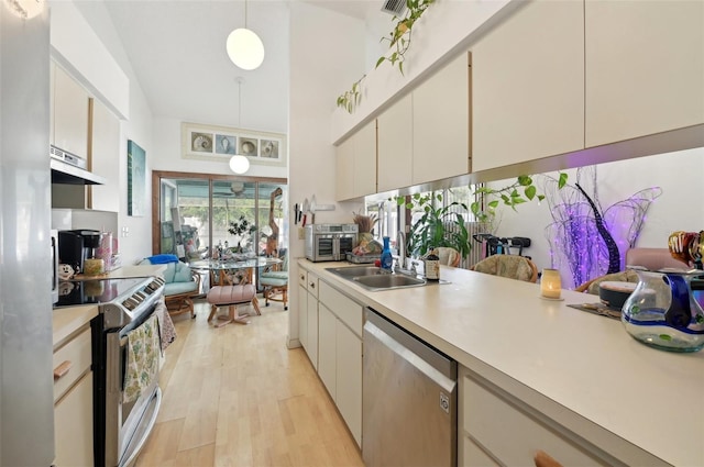 3093 Woodpine Cir, Sarasota, FL 34231 - kitchen with under cabinet range hood, stainless steel appliances, a sink, and light countertops