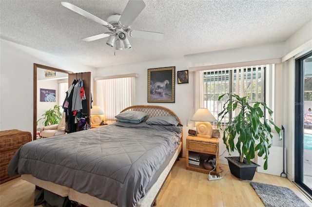 3093 Woodpine Cir, Sarasota, FL 34231 - bedroom featuring a textured ceiling, ceiling fan, and wood finished floors