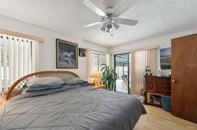 3093 Woodpine Cir, Sarasota, FL 34231 - bedroom featuring a textured ceiling, ceiling fan, access to exterior, and wood finished floors