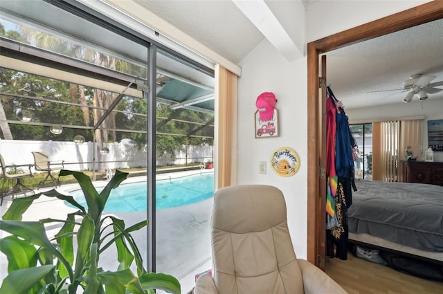 3093 Woodpine Cir, Sarasota, FL 34231 - bedroom with a sunroom, a textured ceiling, access to exterior, and wood finished floors