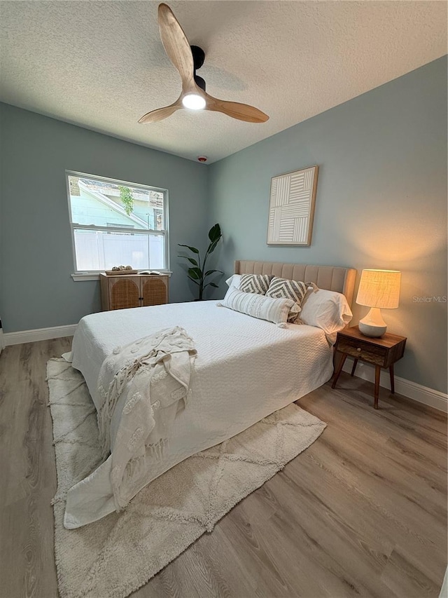 110 Kenwood Ave, Clearwater, FL 33755 - bedroom with wood finished floors, baseboards, ceiling fan, and a textured ceiling