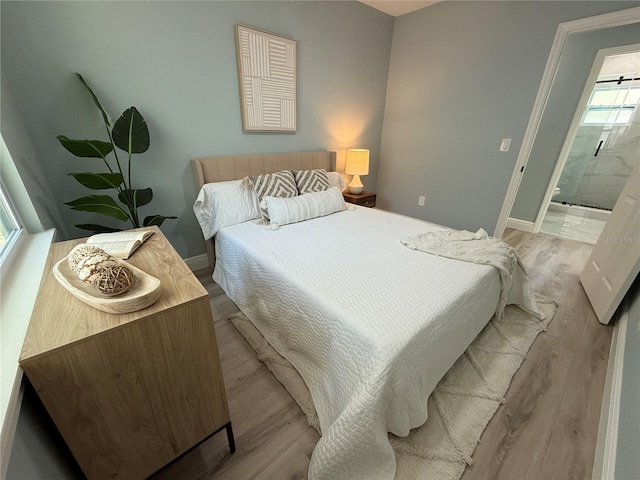 110 Kenwood Ave, Clearwater, FL 33755 - bedroom featuring light wood-style floors, baseboards, and ensuite bath