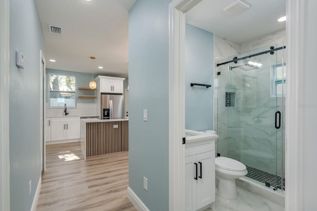 110 Kenwood Ave, Clearwater, FL 33755 - full bathroom with vanity, a marble finish shower, toilet, a textured ceiling, and wood finished floors