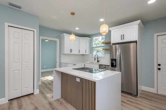 110 Kenwood Ave, Clearwater, FL 33755 - kitchen featuring stainless steel appliances, a sink, open shelves, light wood-style floors, and baseboards