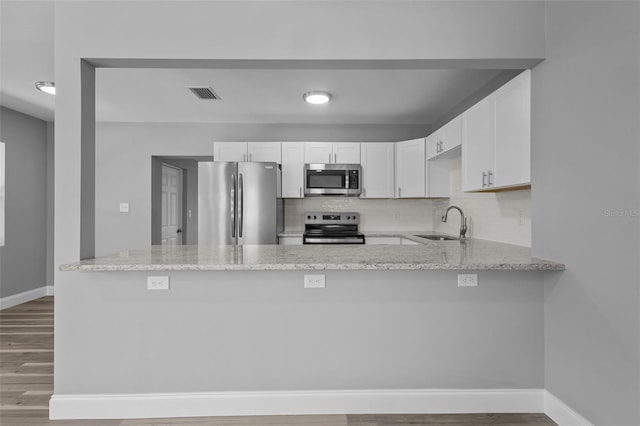 660 Palm Ave, Tarpon Springs, FL 34689 - kitchen featuring a sink, stainless steel appliances, visible vents, a peninsula, and wood finished floors