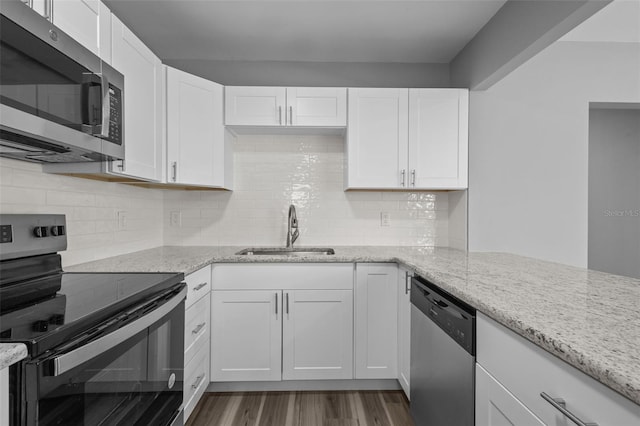 660 Palm Ave, Tarpon Springs, FL 34689 - kitchen featuring wood finished floors, stainless steel appliances, white cabinets, and a sink