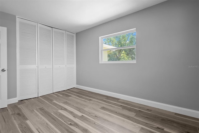660 Palm Ave, Tarpon Springs, FL 34689 - unfurnished bedroom featuring wood finished floors, a closet, and baseboards