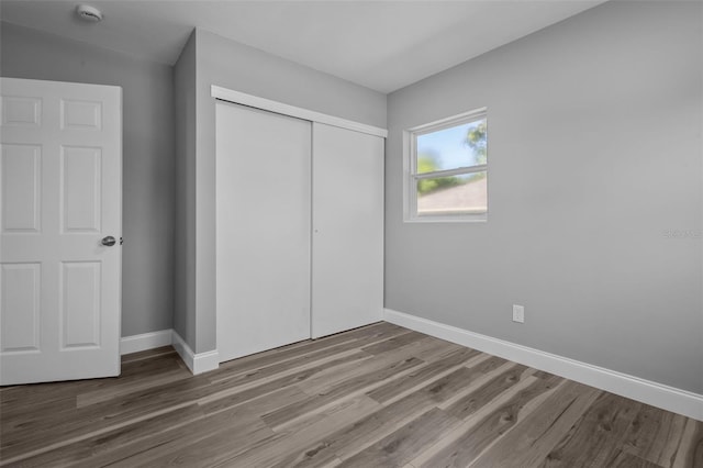 660 Palm Ave, Tarpon Springs, FL 34689 - unfurnished bedroom featuring wood finished floors, a closet, and baseboards