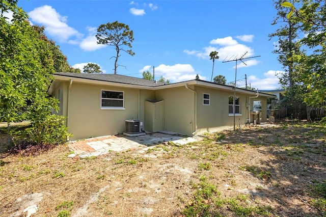 660 Palm Ave, Tarpon Springs, FL 34689 - back of house with stucco siding, fence, and central AC