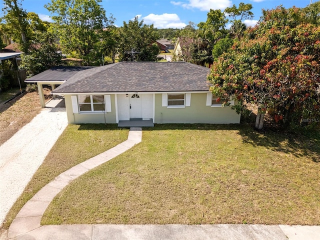 660 Palm Ave, Tarpon Springs, FL 34689 - view of front of house with a front yard, driveway, stucco siding, and roof with shingles