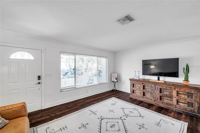 living room with ornamental molding, visible vents, wood finished floors, and baseboards