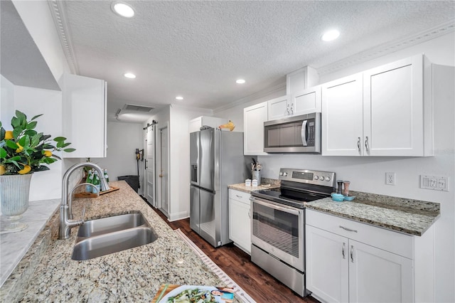 kitchen with dark wood-style floors, a sink, visible vents, a textured ceiling, and appliances with stainless steel finishes