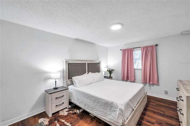 bedroom with baseboards, a textured ceiling, and dark wood-style floors