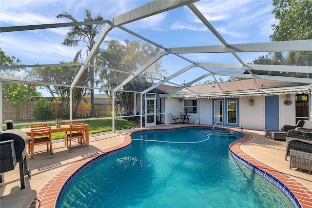 view of swimming pool with a lanai, a fenced in pool, fence private yard, and a patio area