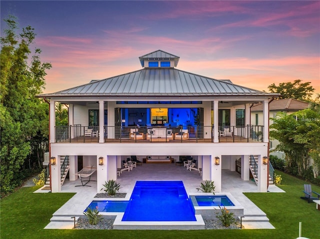 rear view of property featuring a lawn, stairs, and a balcony
