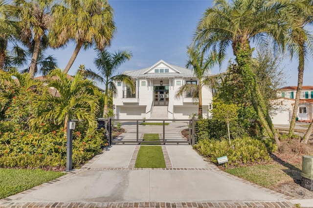 view of front of property with a gate, concrete driveway, and stairway