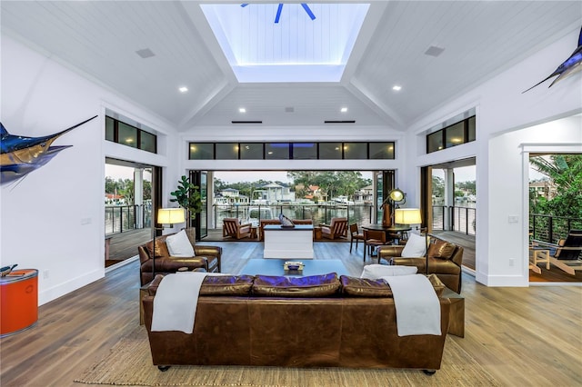 living room featuring baseboards, high vaulted ceiling, wood finished floors, and beamed ceiling