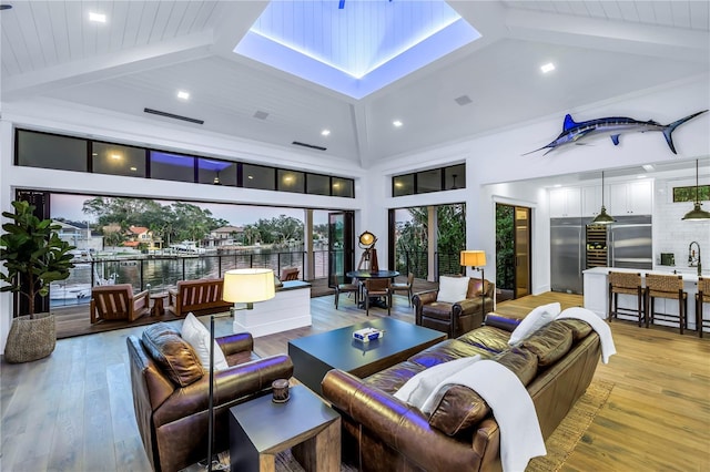 living room featuring recessed lighting, visible vents, beam ceiling, and light wood-type flooring