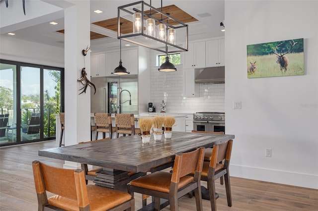 dining room with recessed lighting, baseboards, and light wood finished floors
