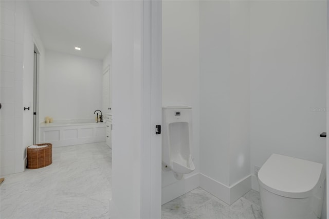 bathroom with a tub, toilet, a sink, and marble finish floor
