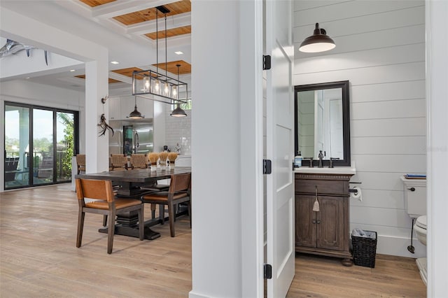 interior space featuring beamed ceiling, stainless steel fridge, recessed lighting, a sink, and light wood-style flooring