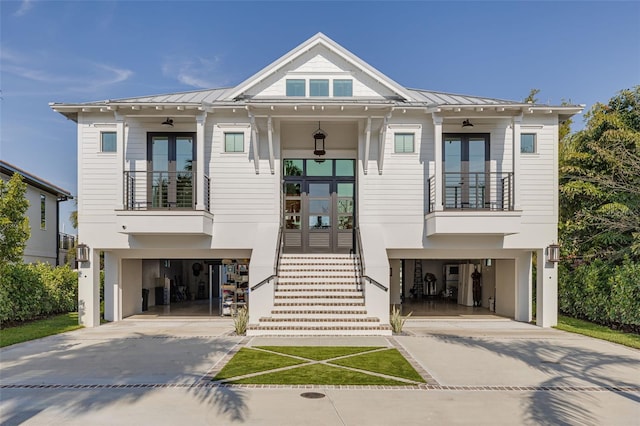 view of front facade featuring concrete driveway, french doors, and a balcony