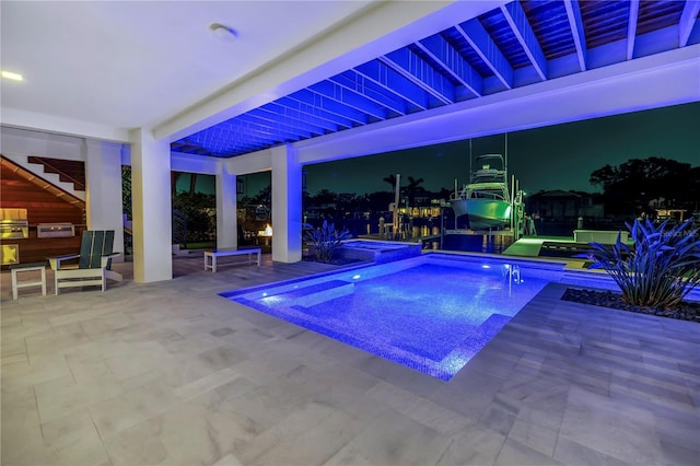 view of pool with a patio, exterior kitchen, and a pool with connected hot tub