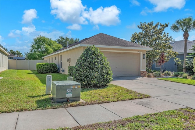 view of side of property with a garage, fence, stucco siding, concrete driveway, and a yard
